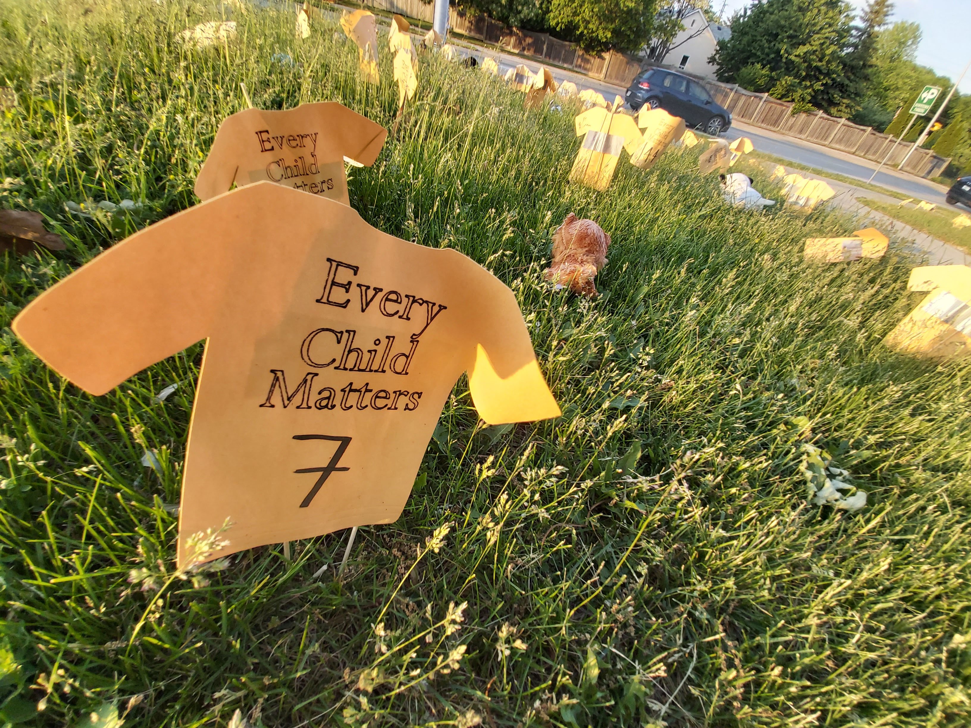 A roadside memorial for the 215 lost children | The road allowance beside St. Thomas Aquinas Catholic Secondary School at Fourth Line and Dorval was filled with orange t-shirt cut outs last week commemorating the 215 children discovered in a mass grave at the site of a former residential school in Kamloops, BC. The residential school was run by the Catholic Church from 1890 to 1969, when it was taken over by the federal government. | Lynn Lau